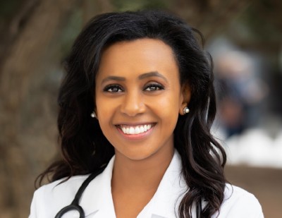 Smiling Eritrean American Woman Doctor Manna Hagos in her white lab coat