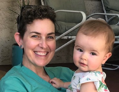 Dr. Alexis Woods with her adorable baby smiling at the camera