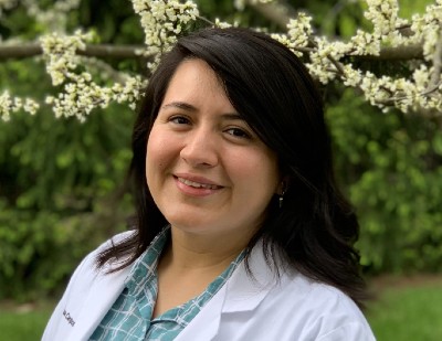 Kryssia Campos smiling under a blossom tree