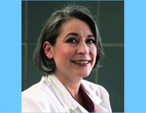 Dr. Raquel Arias smiling at the camera in her lab coat